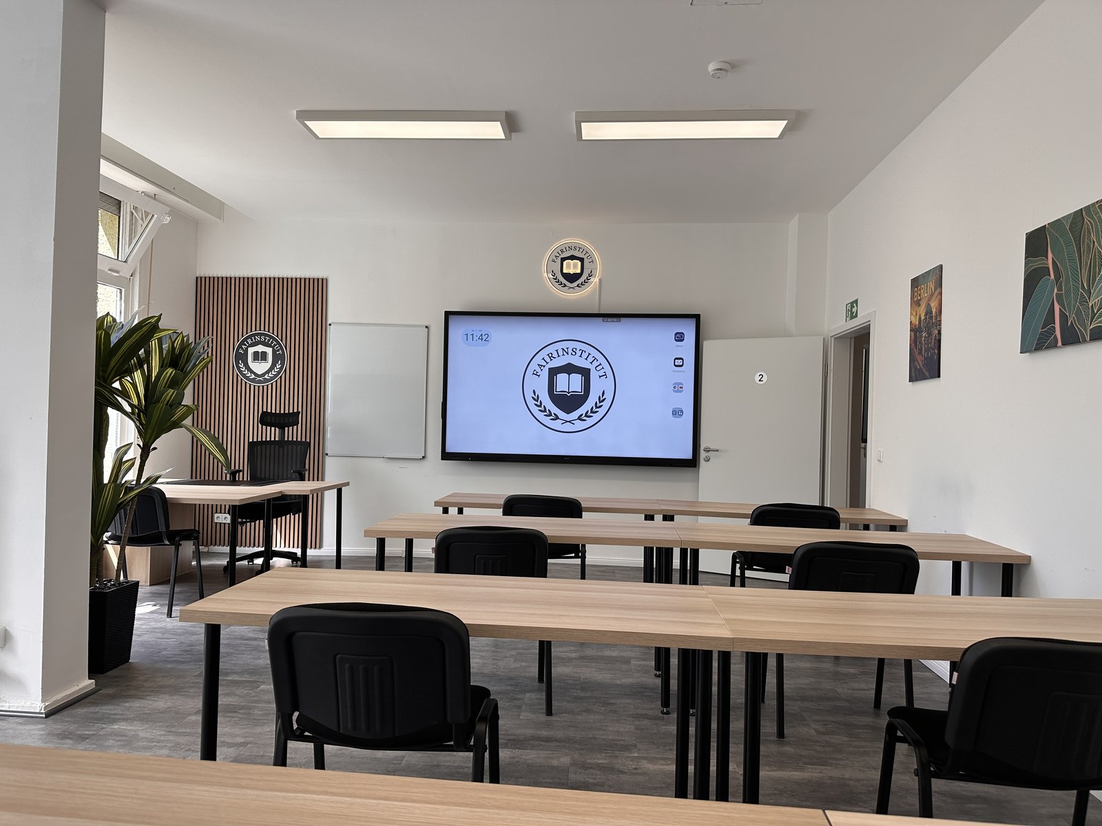 Klassenraum des fairInstitut mit Smartboard und beleuchtetem Wappen in Berlin Mitte-Moabit
